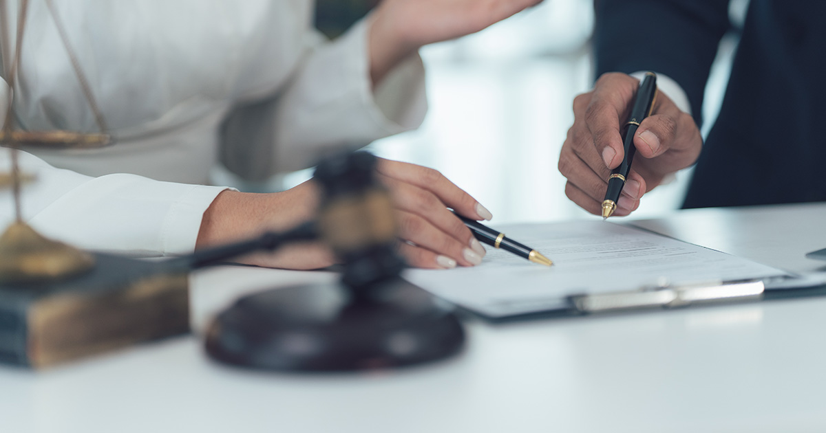 Legal advice: Close-up of a lawyer and his client reviewing legal documents